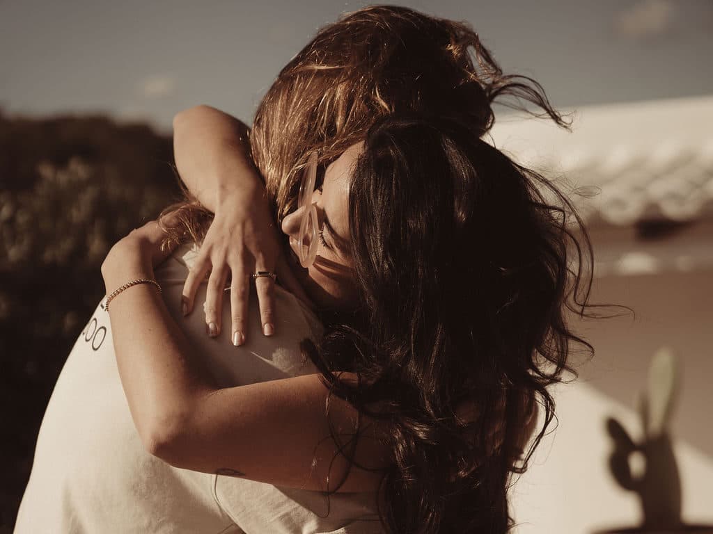 Two people in a warm embrace in golden sunlight